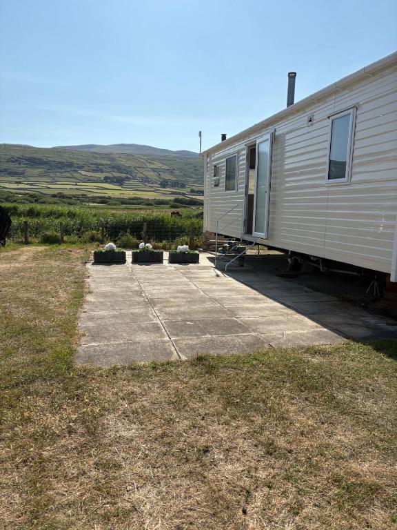 an rv parked in a field with some plants at Dotties Den at Sunnysands in Llanddwywe