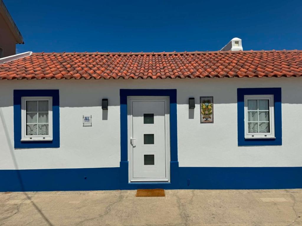 a blue and white house with a door and two windows at Casa Isqueiro in Cela