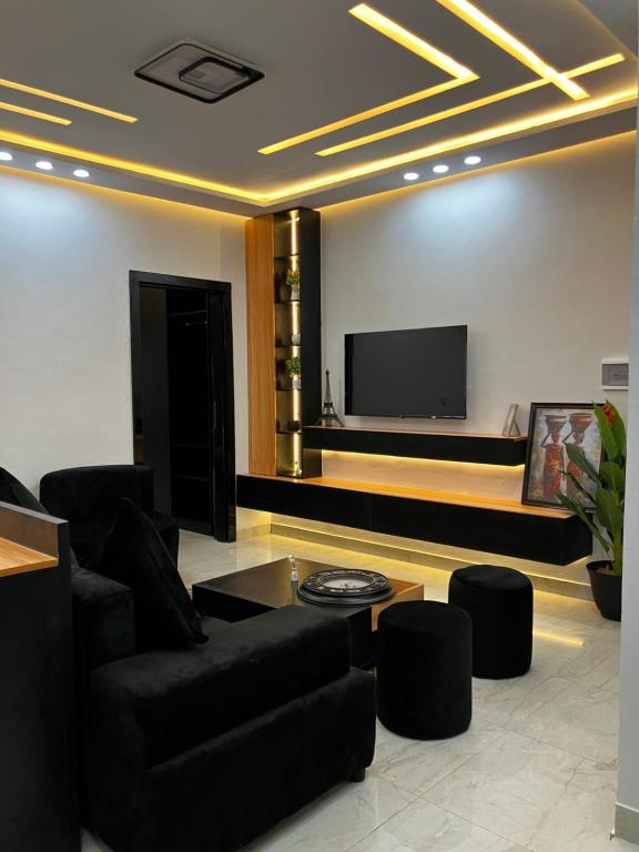 a living room with a couch and a flat screen tv at Le confort dans la simplicité in Lomé