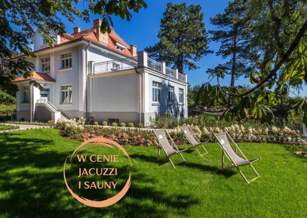 a group of lawn chairs in front of a house at Villa Testa in Sopot