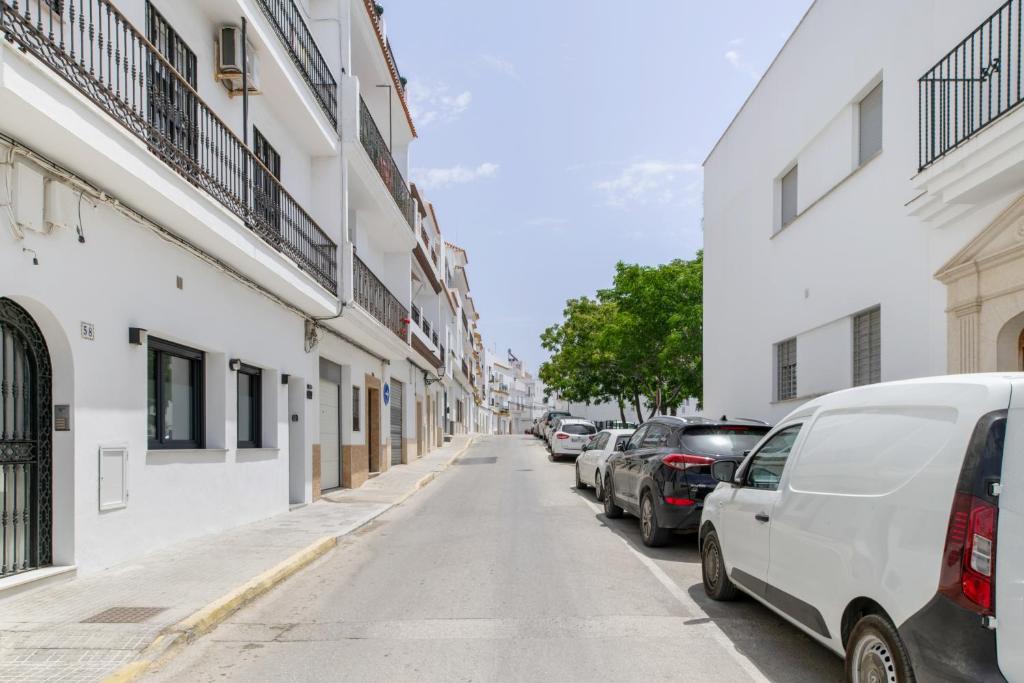 a street with cars parked on the side of a building at Apartamentos Surya Home Suites in Conil de la Frontera