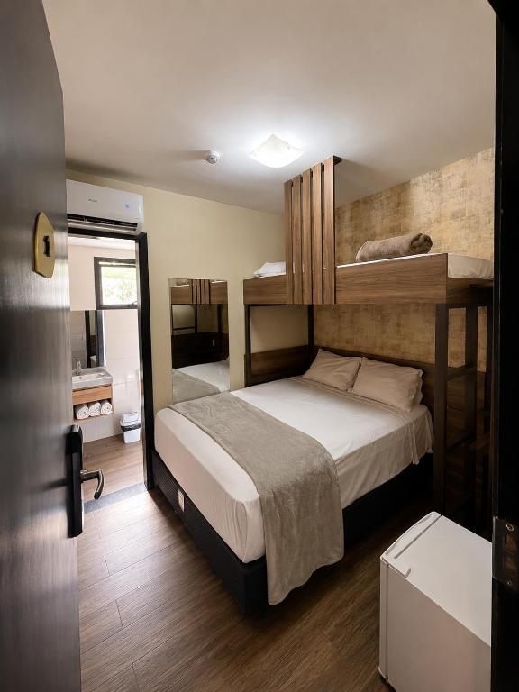 a bedroom with a bed with two bunk beds at Uny Hotéis Brás in São Paulo