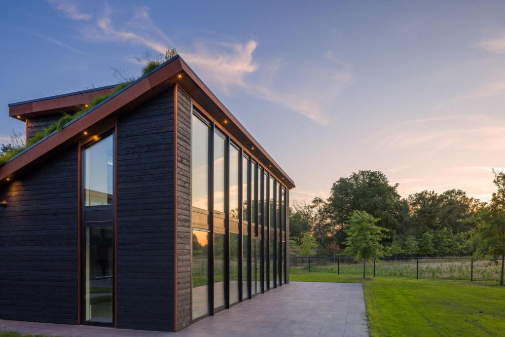 a house with black siding and large windows at OplooPark Forrest Villa in Oploo