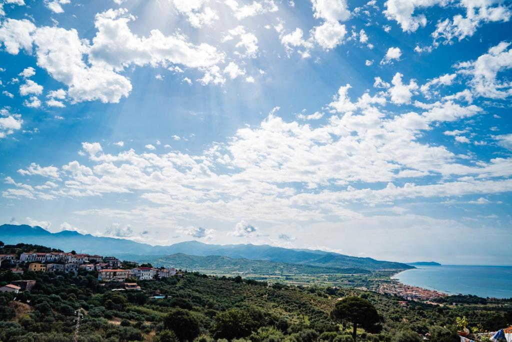 a view of a city and the ocean under a cloudy sky at Tenuta la Selva Casa I Lavatoi in Casal Velino