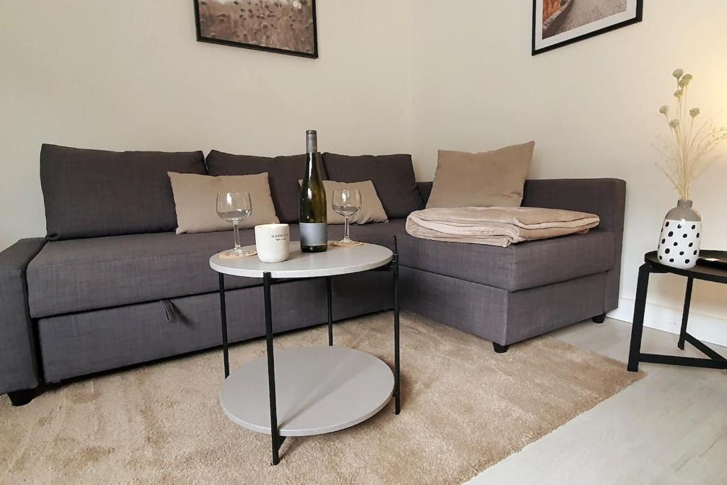 a living room with a gray couch and two tables at Mosel Appartment in Briedel in Briedel