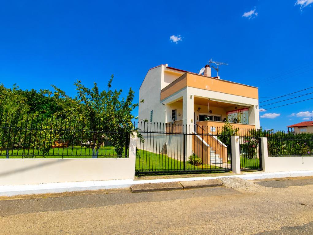 a house with a gate in front of it at Angela's House in Nea Plagia