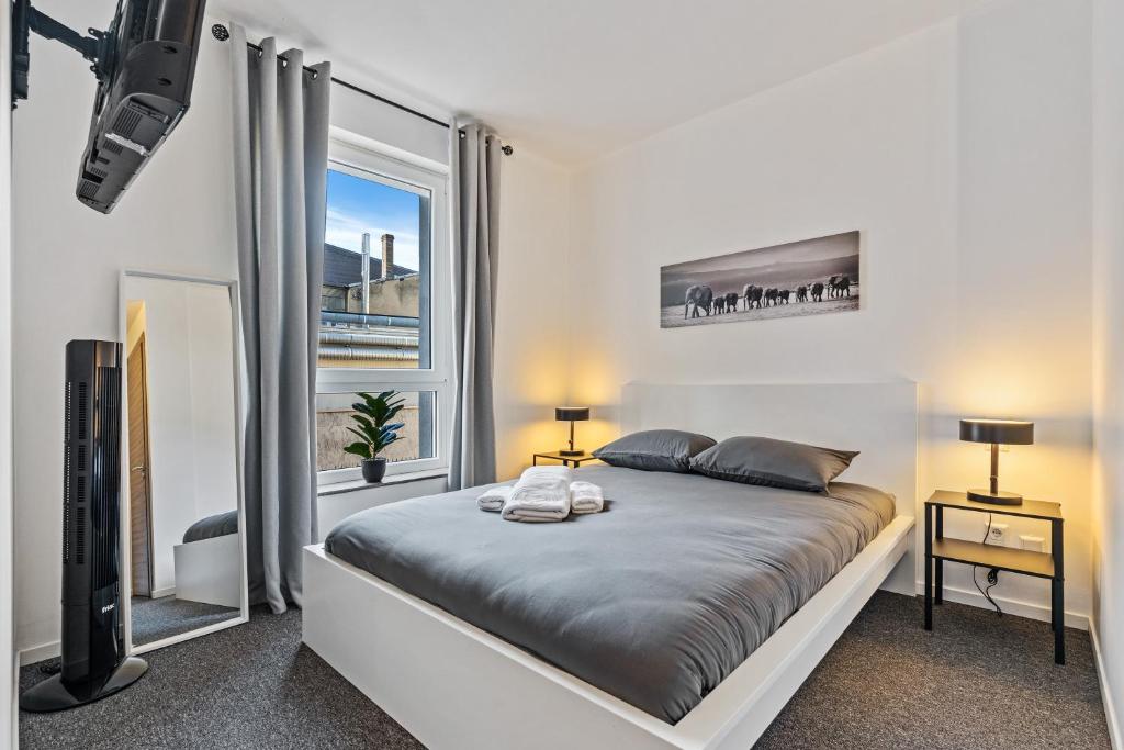 a bedroom with a bed and a large window at Hotel Stay Properties in Luxembourg
