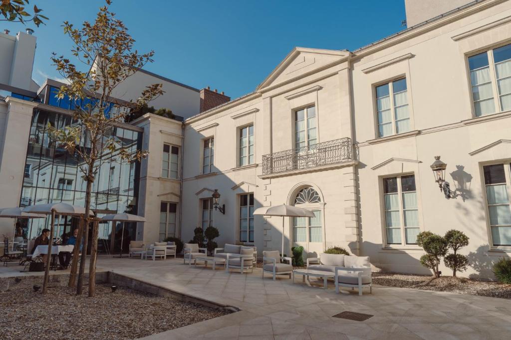 a courtyard of a building with chairs and umbrellas at Maison Maubreuil in Nantes