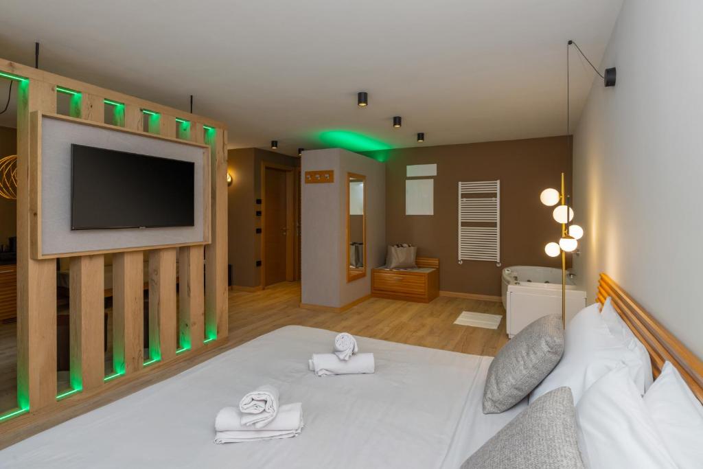 a living room with a bed with a flat screen tv at Cavallino Experience - Alpine Wellness Hotel in Rumo