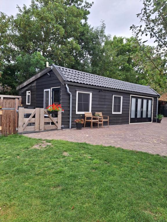 a black shed with a picnic table in a yard at Guesthouse Bij Maud in Barsingerhorn