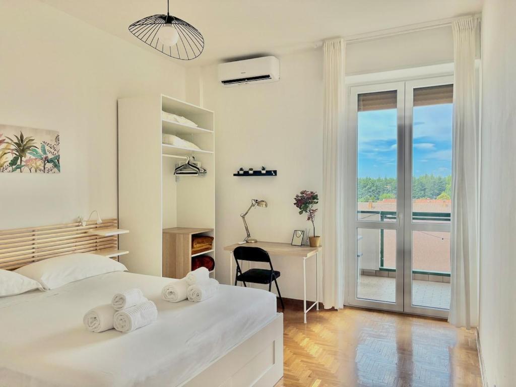 a bedroom with a bed and a desk and a window at Bellavista Apartment Arcore in Arcore