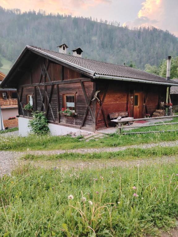 a large wooden house with a field in front of it at Ciasa Lovara in Lovara