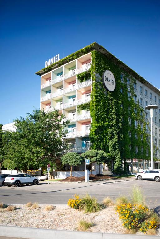 a building covered in green ivy next to a street at Hotel Daniel Graz - Smart Lifestyle Near City Centre in Graz