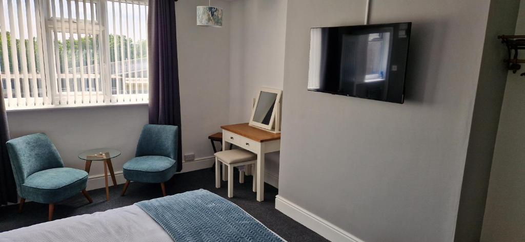 a hotel room with a bed and a television on a wall at Moon Tap Hideaway in Bridlington