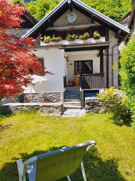 a green chair in front of a small house at la Mansarda dello Zio in Ceppo Morelli