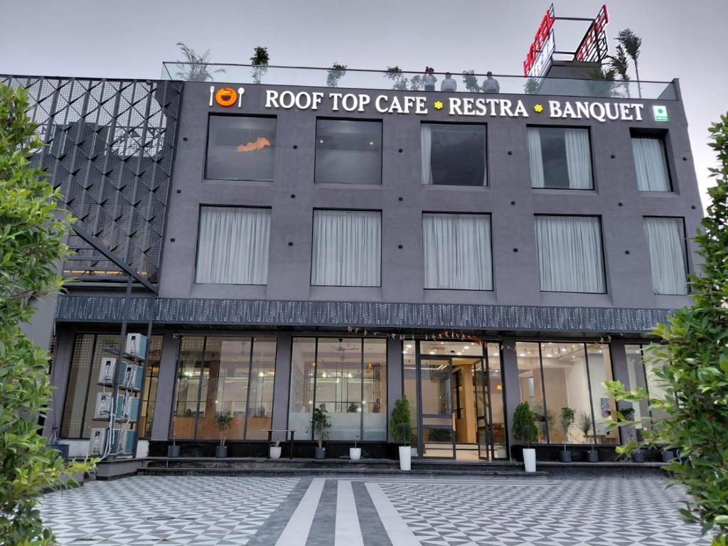 a building with a roof top cafe restaurant at Hotel Arena in Nasīrābād