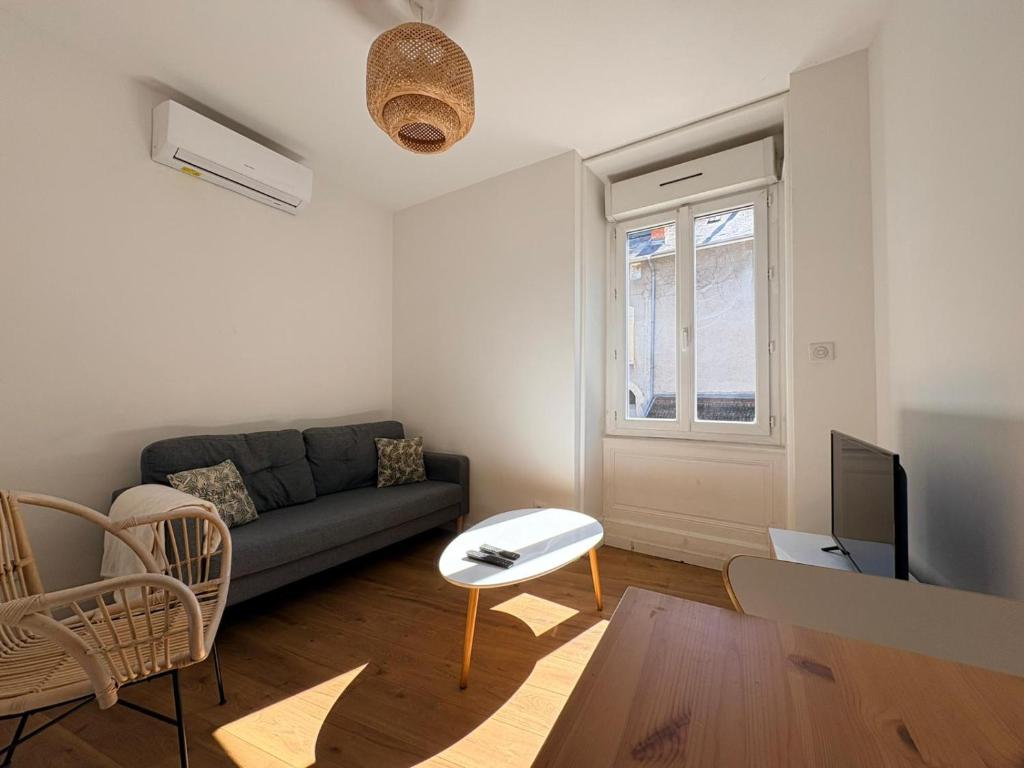 a living room with a couch and a tv at Appartement La Jungle in Villebois