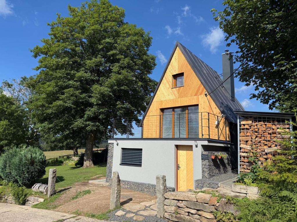 a house with a gambrel roof and a white garage at Chalet Galla in Horní Blatná
