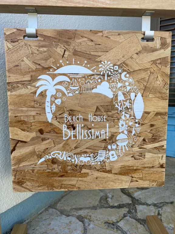a wooden sign with a beach house britishishtail at Beach House Bellissima ! in Yomitan