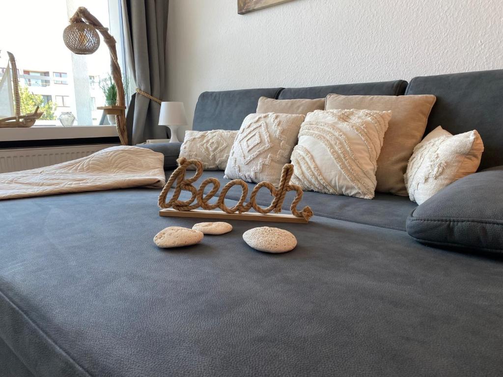 a couch with pillows and a baby sign on it at Ferienwohnung Ostseeverliebt 1-6-1 in Kellenhusen