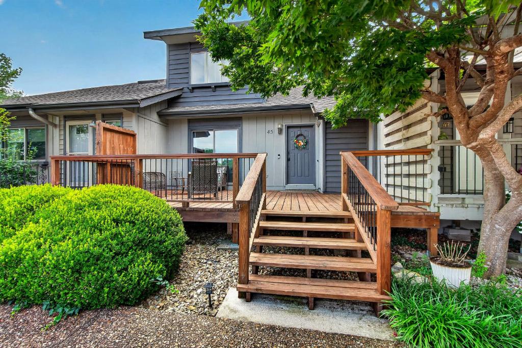 a house with a wooden deck in front of it at Birdies & Bikes at Fairway 45 in Bella Vista