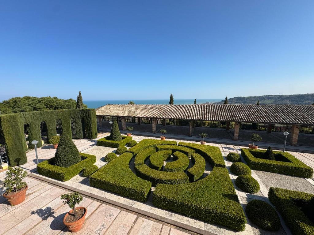 a garden with a hedge maze and a building at B&B Dimora Aura in Cupra Marittima