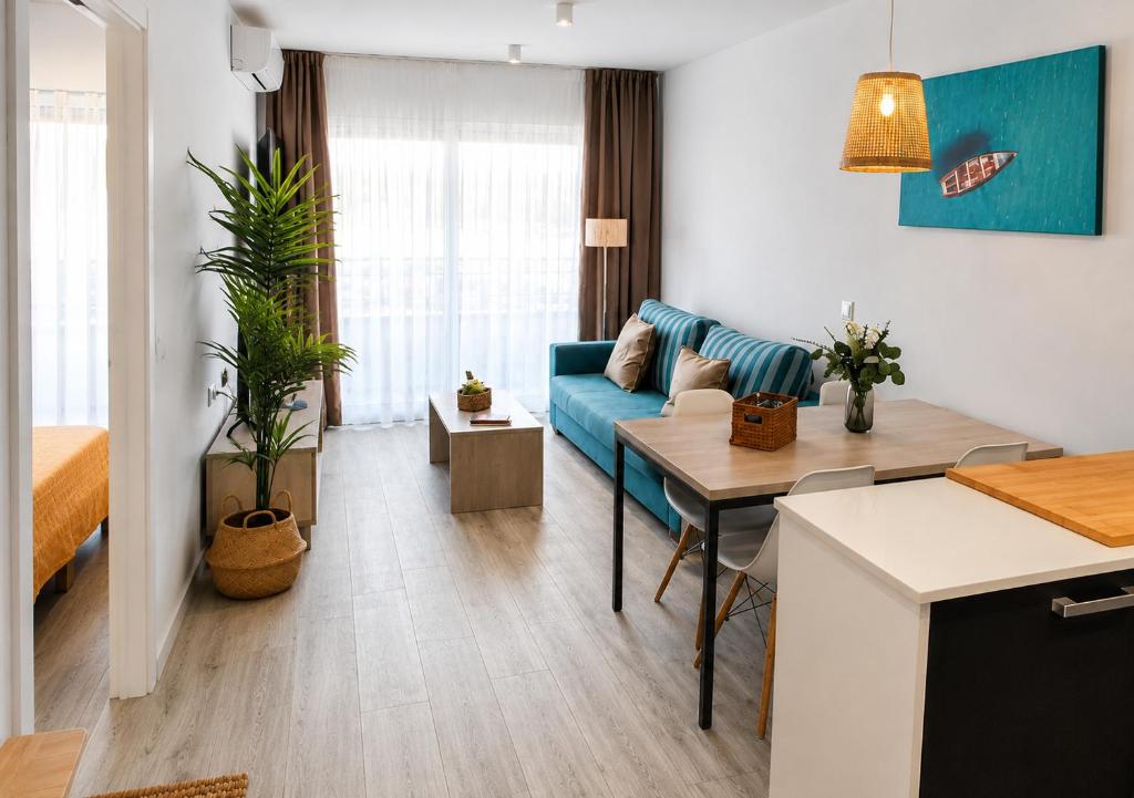 a living room with a blue couch and a table at Festasol - Apartament Estartit in Torroella de Montgrí