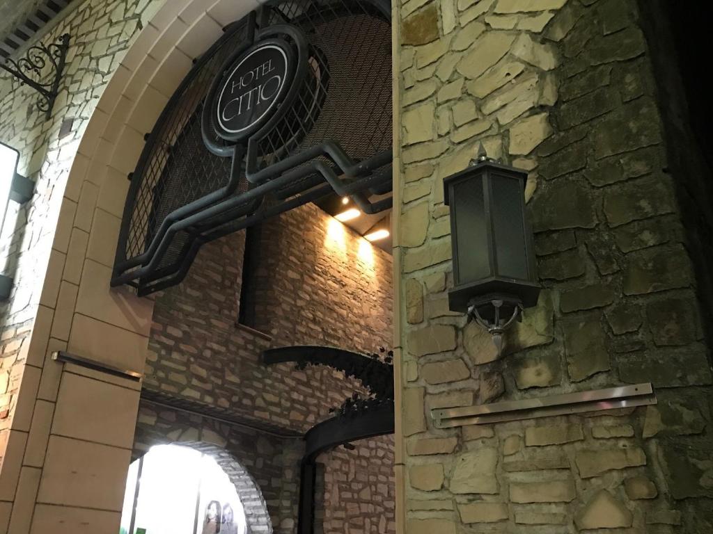 a sign on the side of a brick wall with a lamp at Hotel Citio Shizuoka in Shizuoka