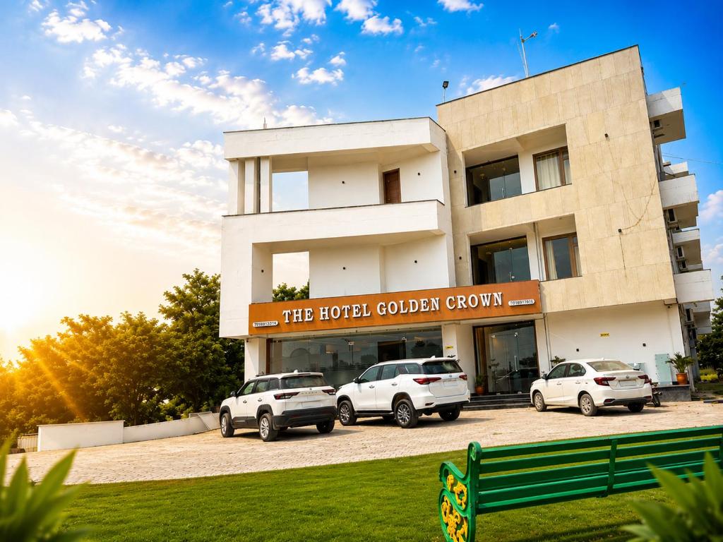 a building with three cars parked in front of it at The hotel golden crown in Baddi