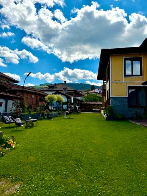 a yard of a house with a green lawn at Арбория in Koprivshtitsa