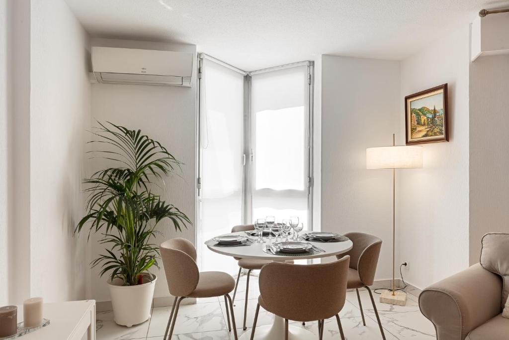 a white dining room with a table and chairs at Suite Sainte-Hélène FSHH in Nice