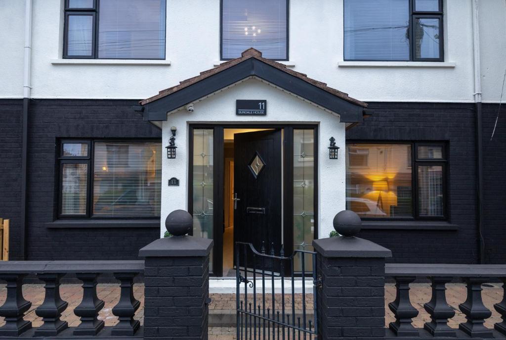 a black and white house with a black door at Sundale House in Lurgan
