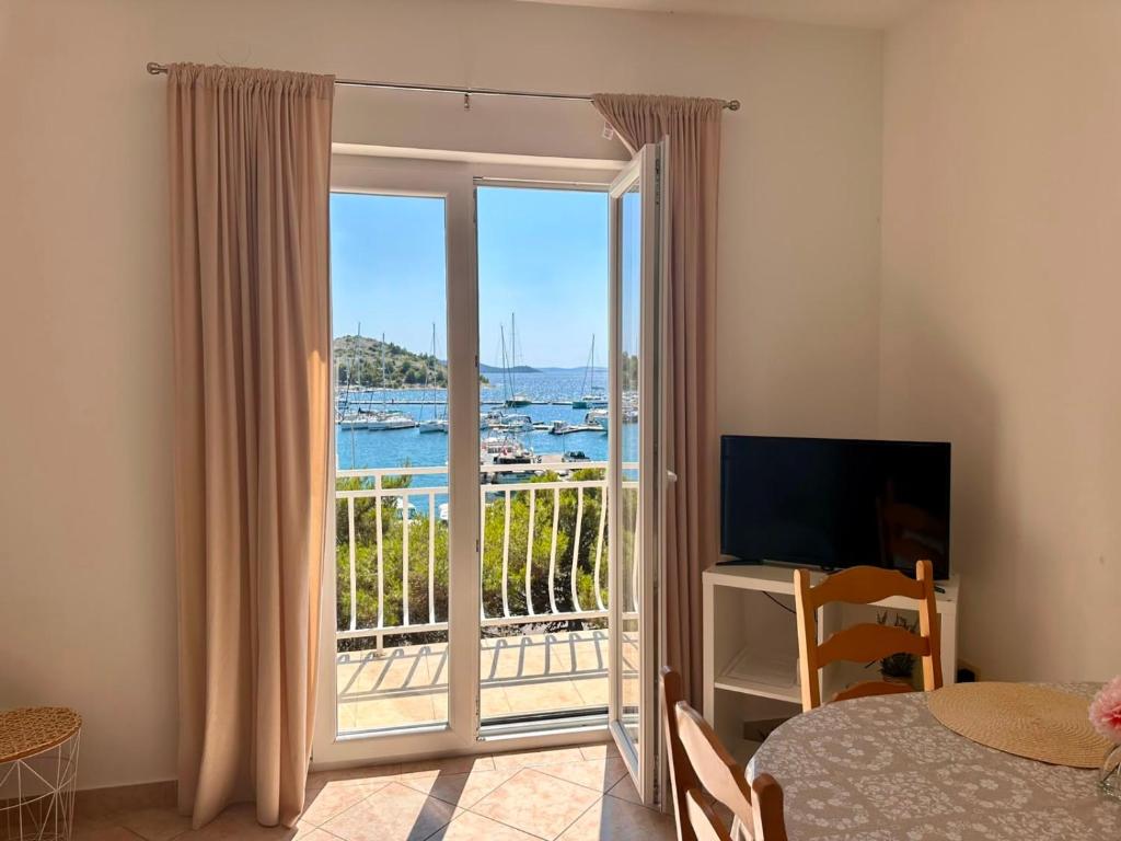 a bedroom with a sliding glass door with a balcony at Apartments Mustel Drage - Adults Only in Drage