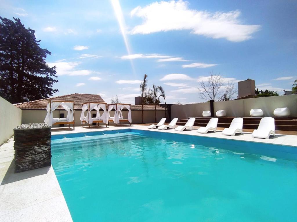 a swimming pool with lounge chairs and a swimming pool at Hotel Astoria in Villa Carlos Paz