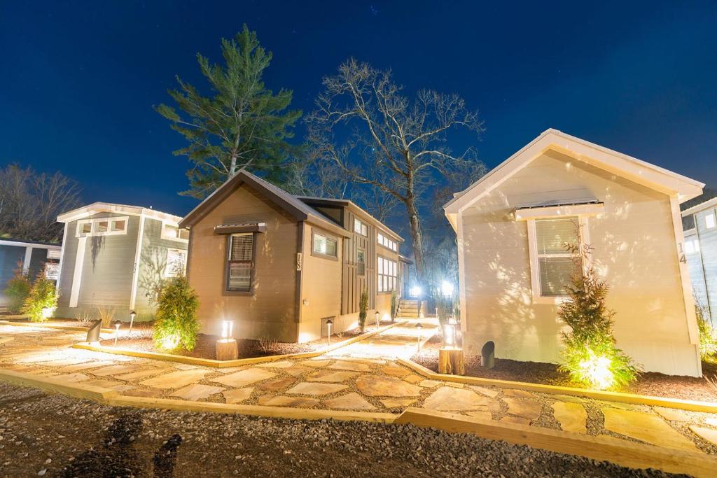 a small house with lights in a yard at night at Deers Den River- Luxury Tiny Home on River in Bryson City