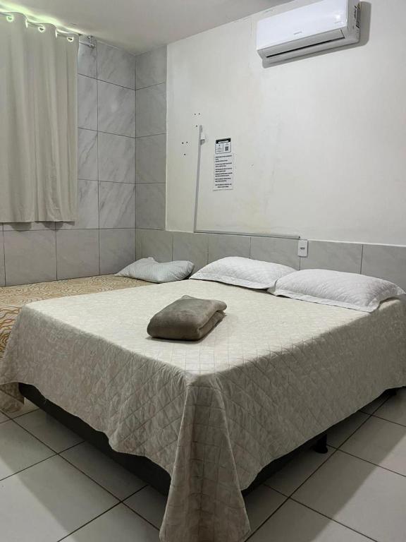 a bed with a blanket on it in a room at Jardim Tropical in Bayeux