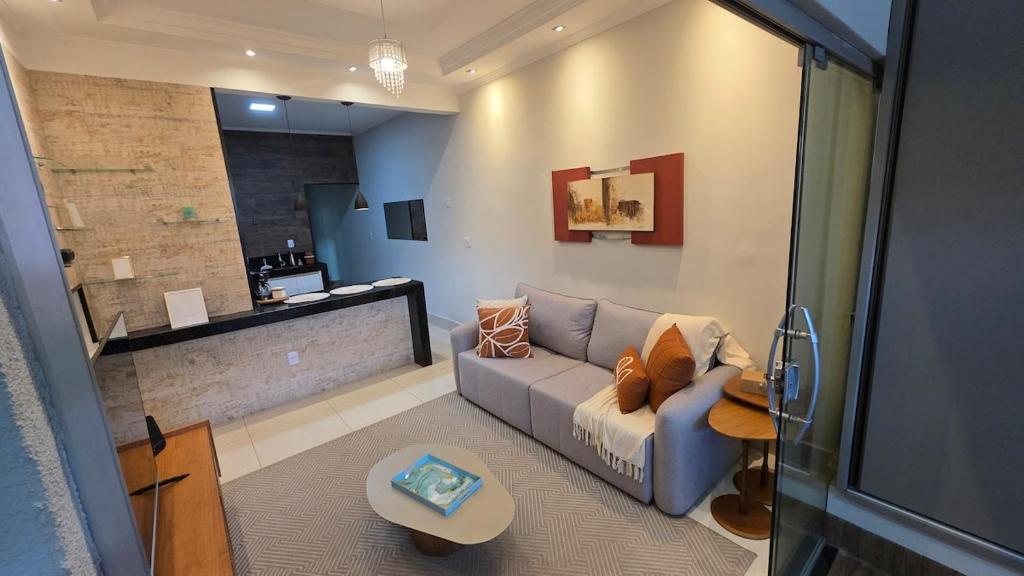a living room with a couch and a table at Casa Completa e Confortável para sua Estadia in Ribeirão Preto