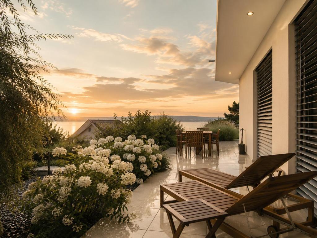 a patio with chairs and flowers on a house at LAKEVIEW - 2 bedroom stay with Sauna and parking on Lake Constance in Berlingen