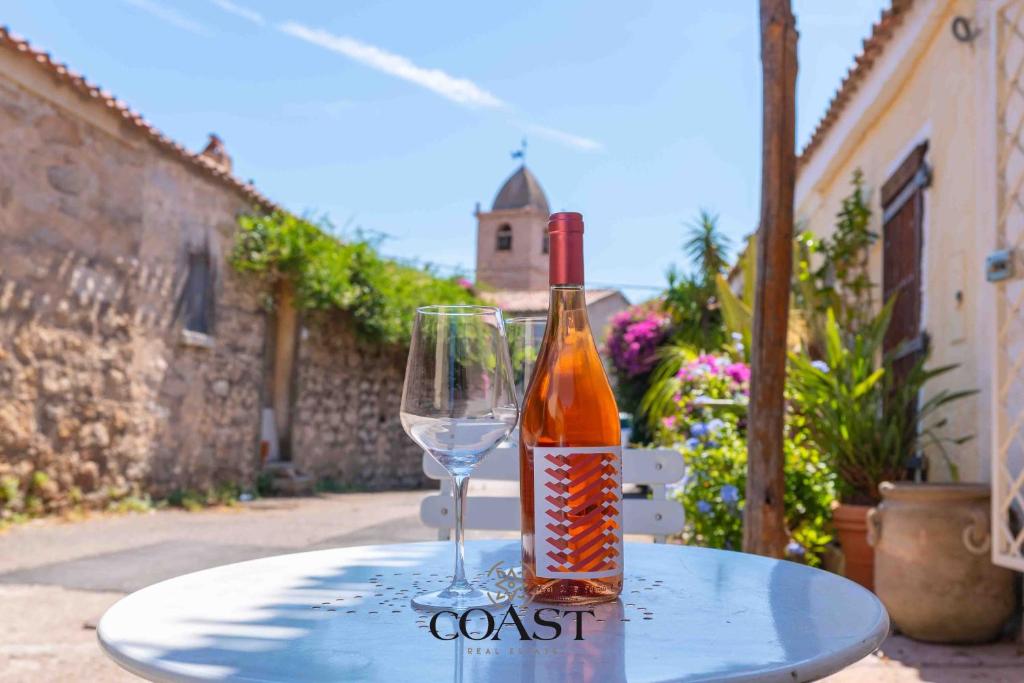 a bottle of wine and a glass on a table at San Pantaleo Charme in San Pantaleo