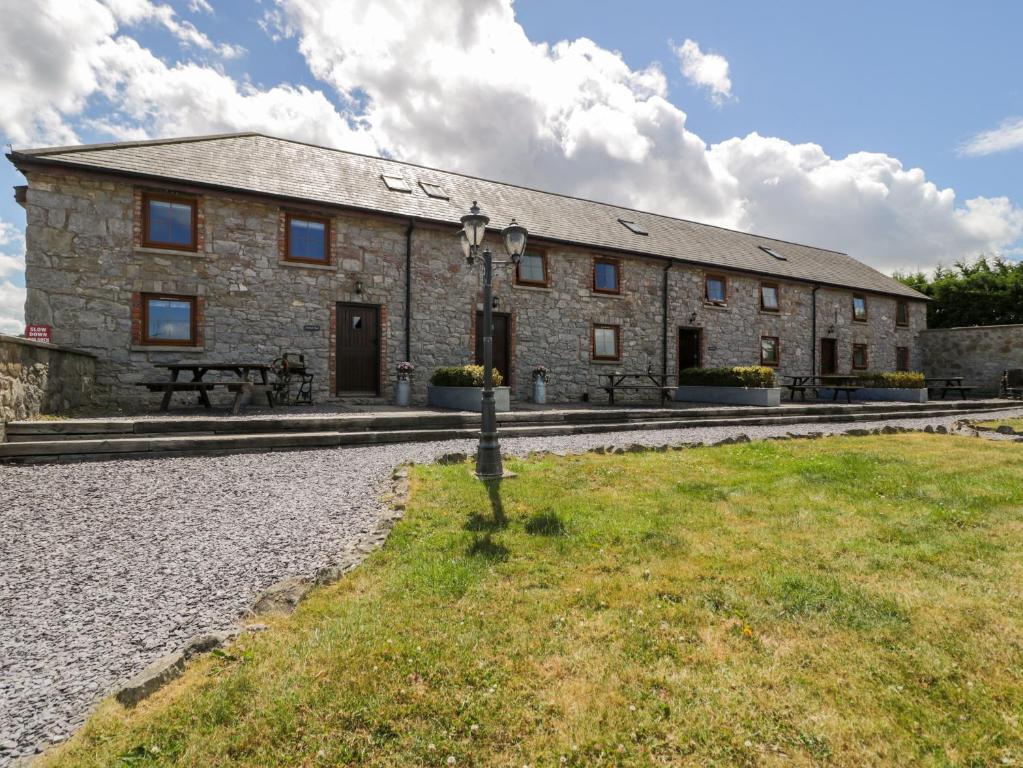 a large stone building with a bench in front of it at Bwthyn Y Wennol in Llanddulas