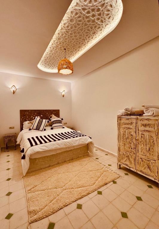 a bedroom with a large bed and a wooden dresser at Riad Kimee in Marrakesh