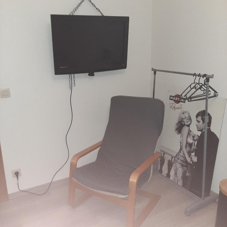 a living room with a chair and a flat screen tv at Italian stile in Spa