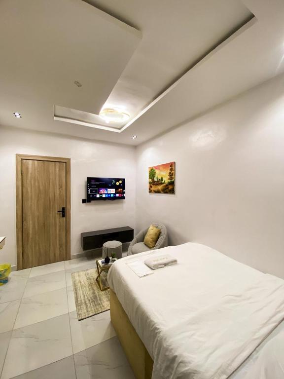 a bedroom with a bed and a tv on the wall at Declevor Homes in Lekki