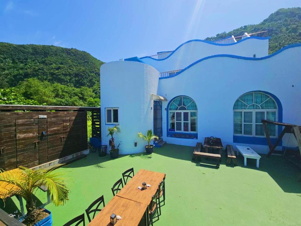 a blue and white house with a table and chairs at Green Island Starry Night Hostel in Green Island