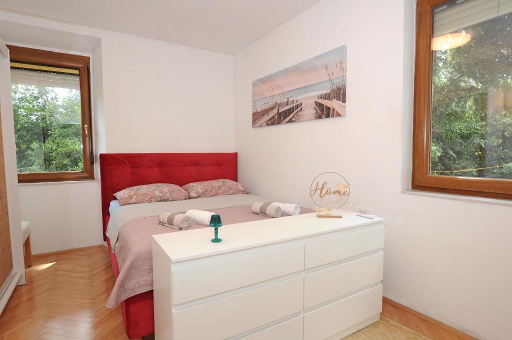 a white bedroom with a bed and a dresser at HOLIDAY's HOUSE in Semedela