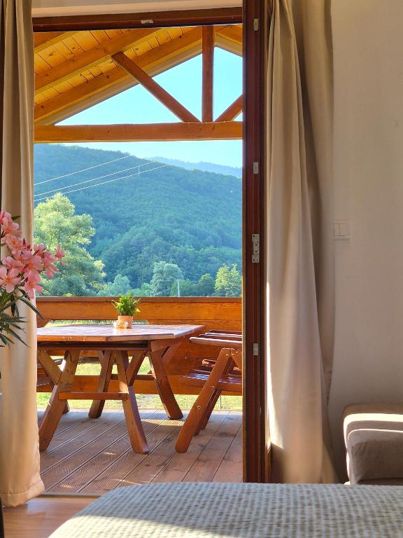 a balcony with a table and a view of a mountain at Kućica na jezeru in Jezero