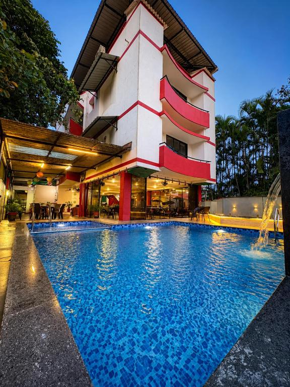 a hotel with a swimming pool in front of a building at Girivihar Holiday Club - Pure Veg in Lonavala