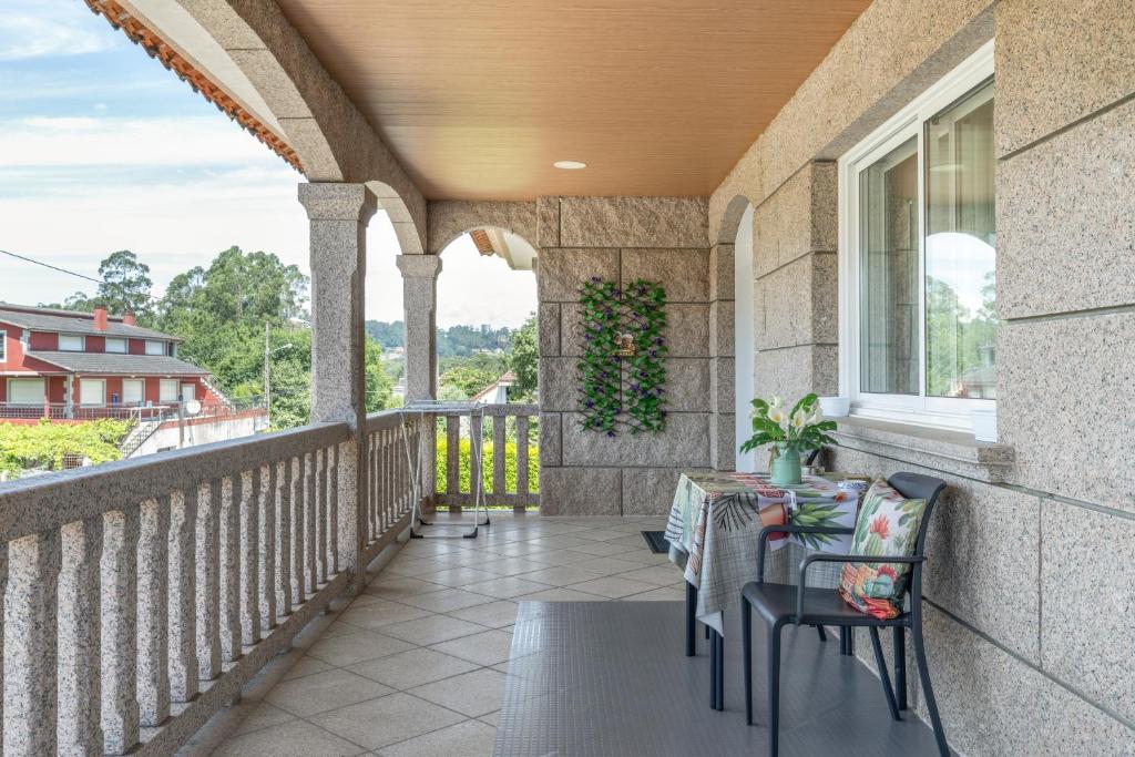 a patio with a table and chairs on a balcony at Os Cabaleiros in Mos