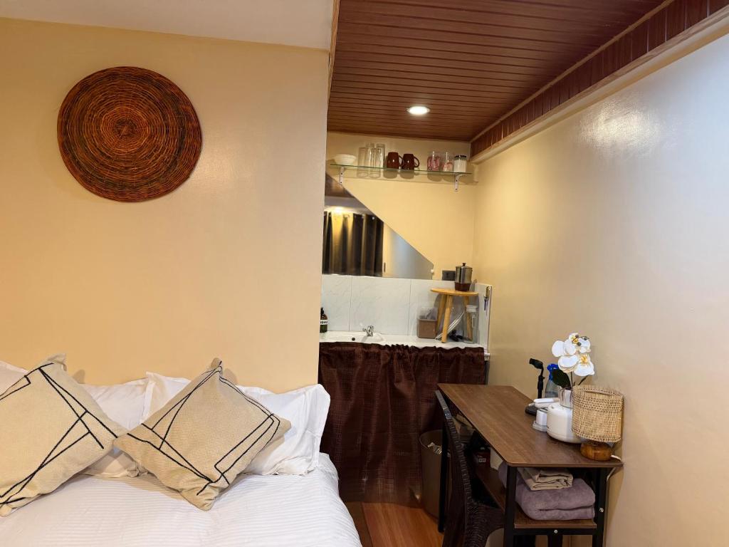 a bedroom with a bed and a desk and a staircase at Bahay El Nido in El Nido