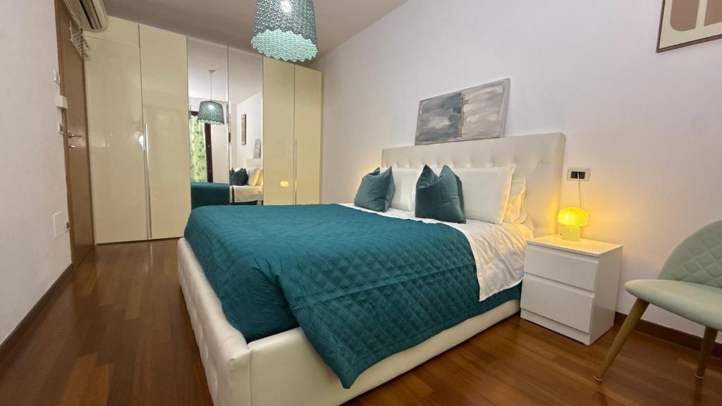 a bedroom with a large bed with a blue blanket at Crystal House in Montesilvano